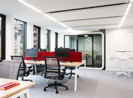 Aménagement d'un bureau en flex office avec des cabines acoustiques pour réduire les nuisances sonores. Espace de travail avec des positons variés pour limiter les troubles musculo-squelletiques